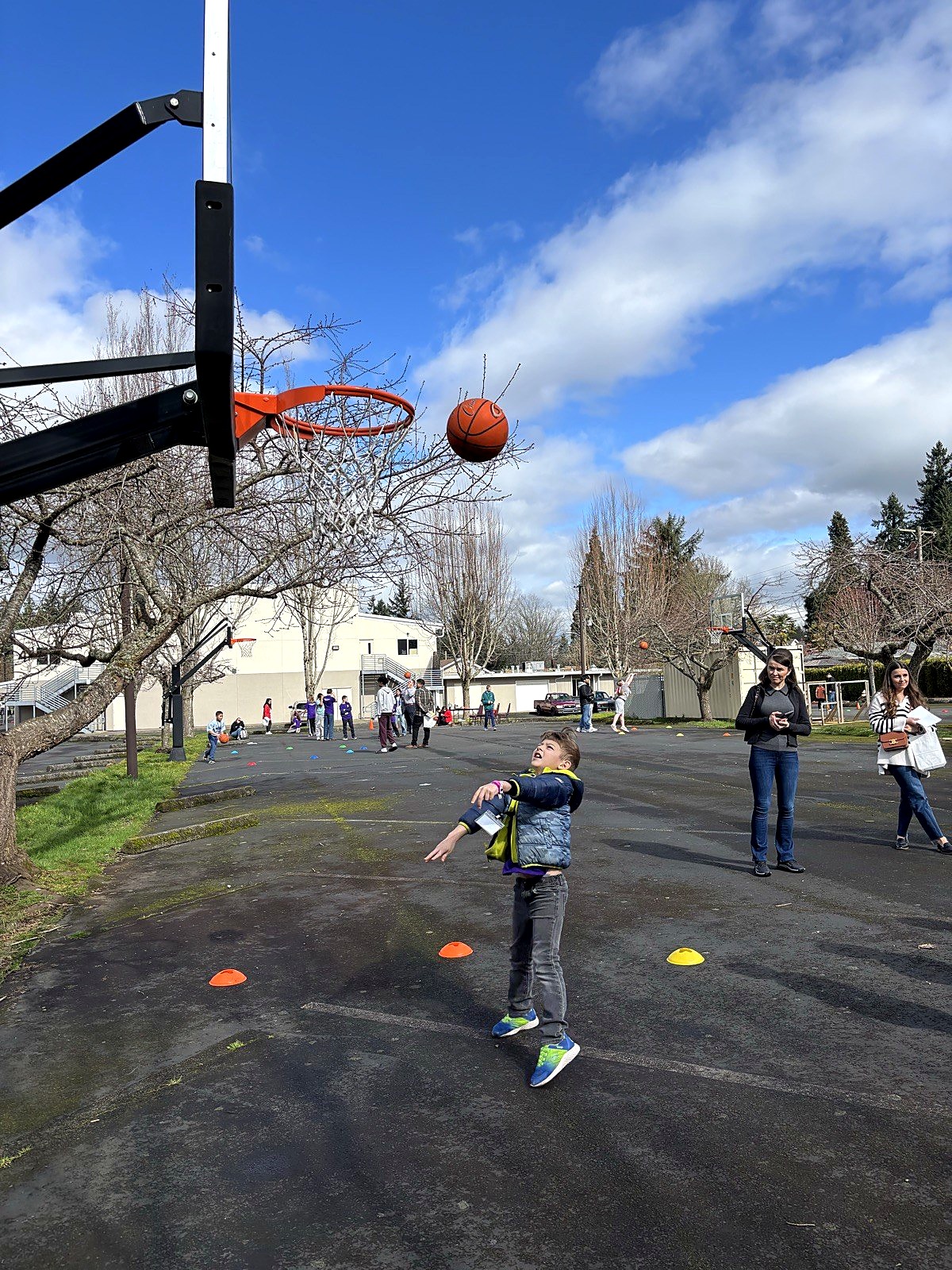 A Spring Mountain student playing basketball at recess on the outdoor blacktop