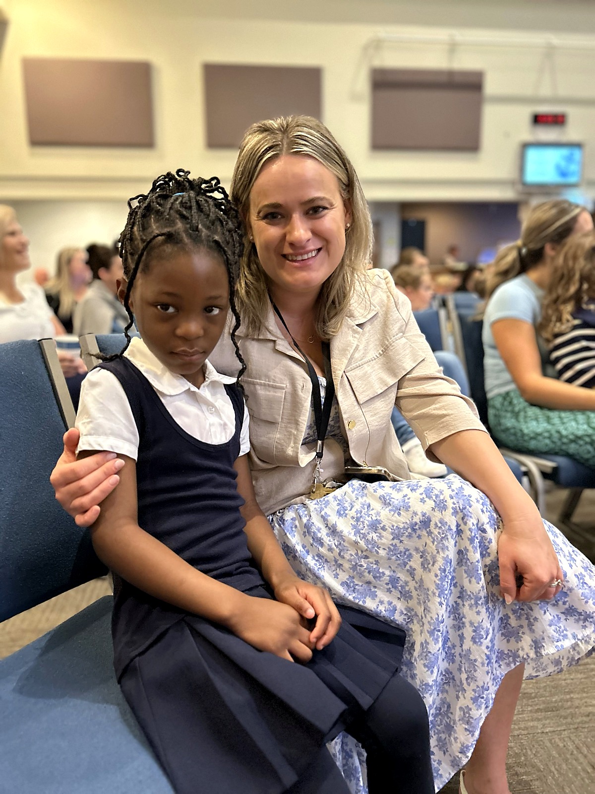 A Spring Mountain teacher with her arm around a young student at a school gathering