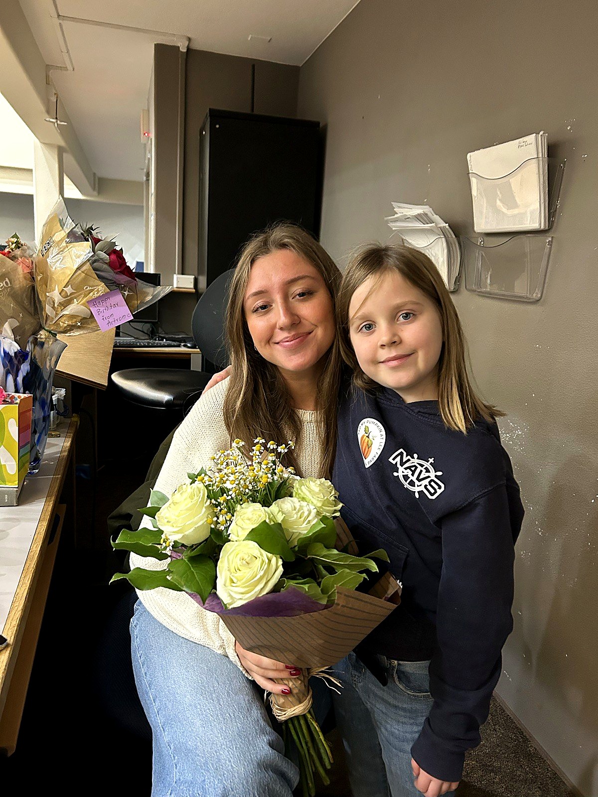 A Spring Mountain teacher with a young student holding flowers