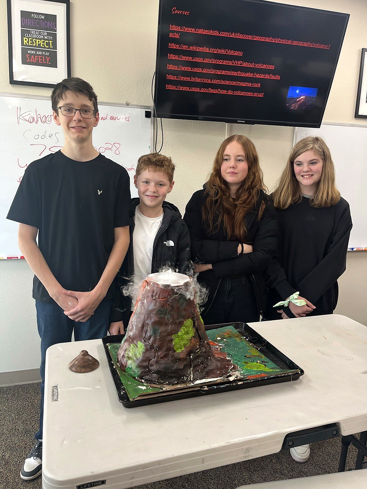 Middle school students presenting an erupting volcano science model