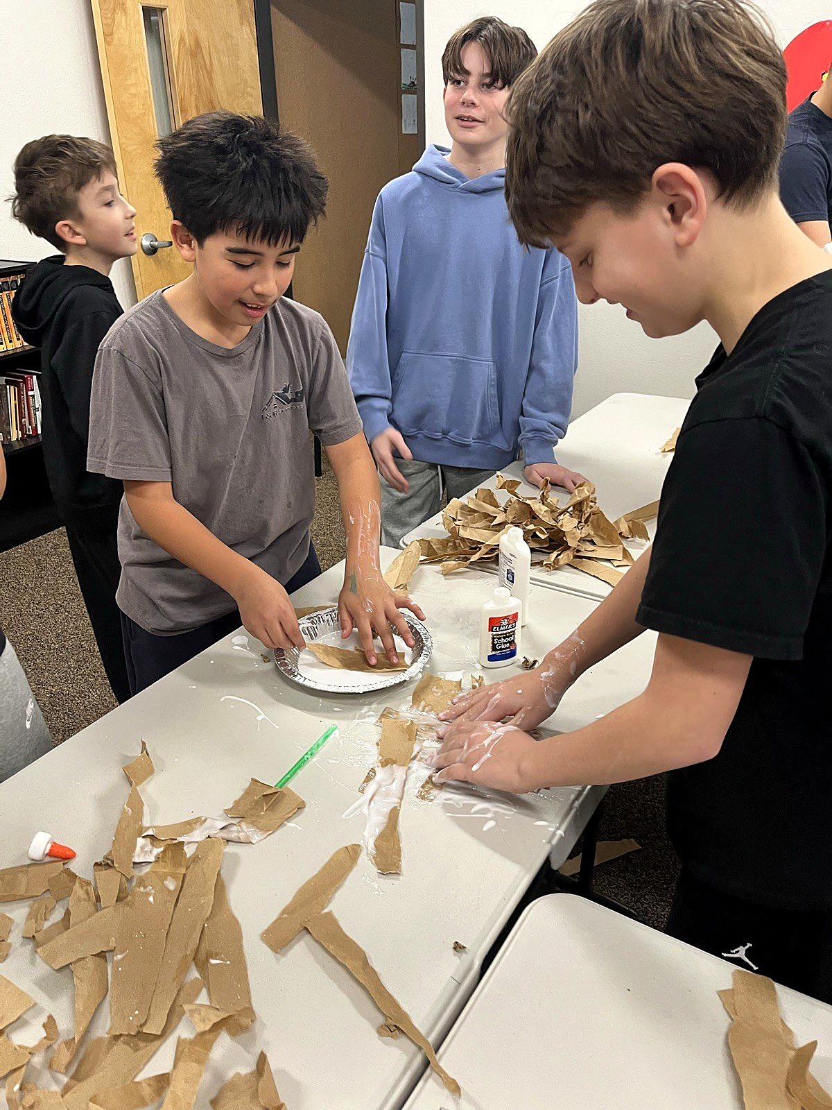 Middle school students working together on a hands-on craft project
