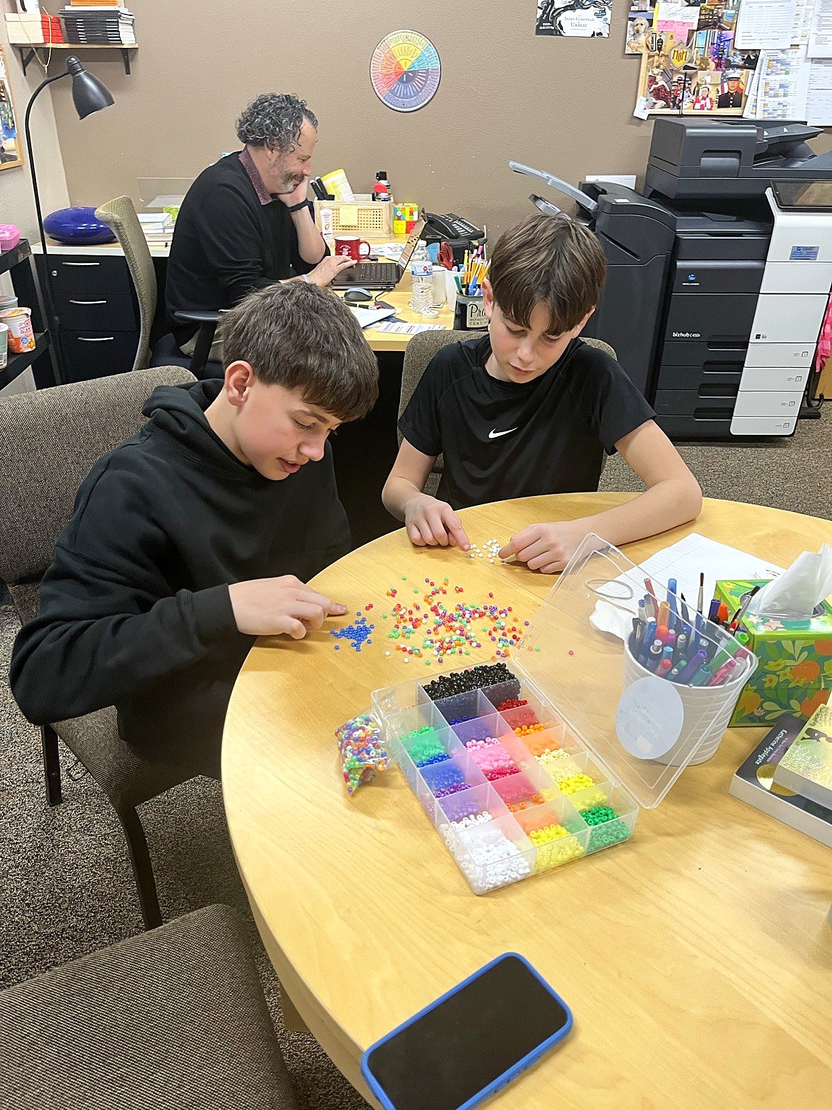 Two students focused on a detailed beadwork project