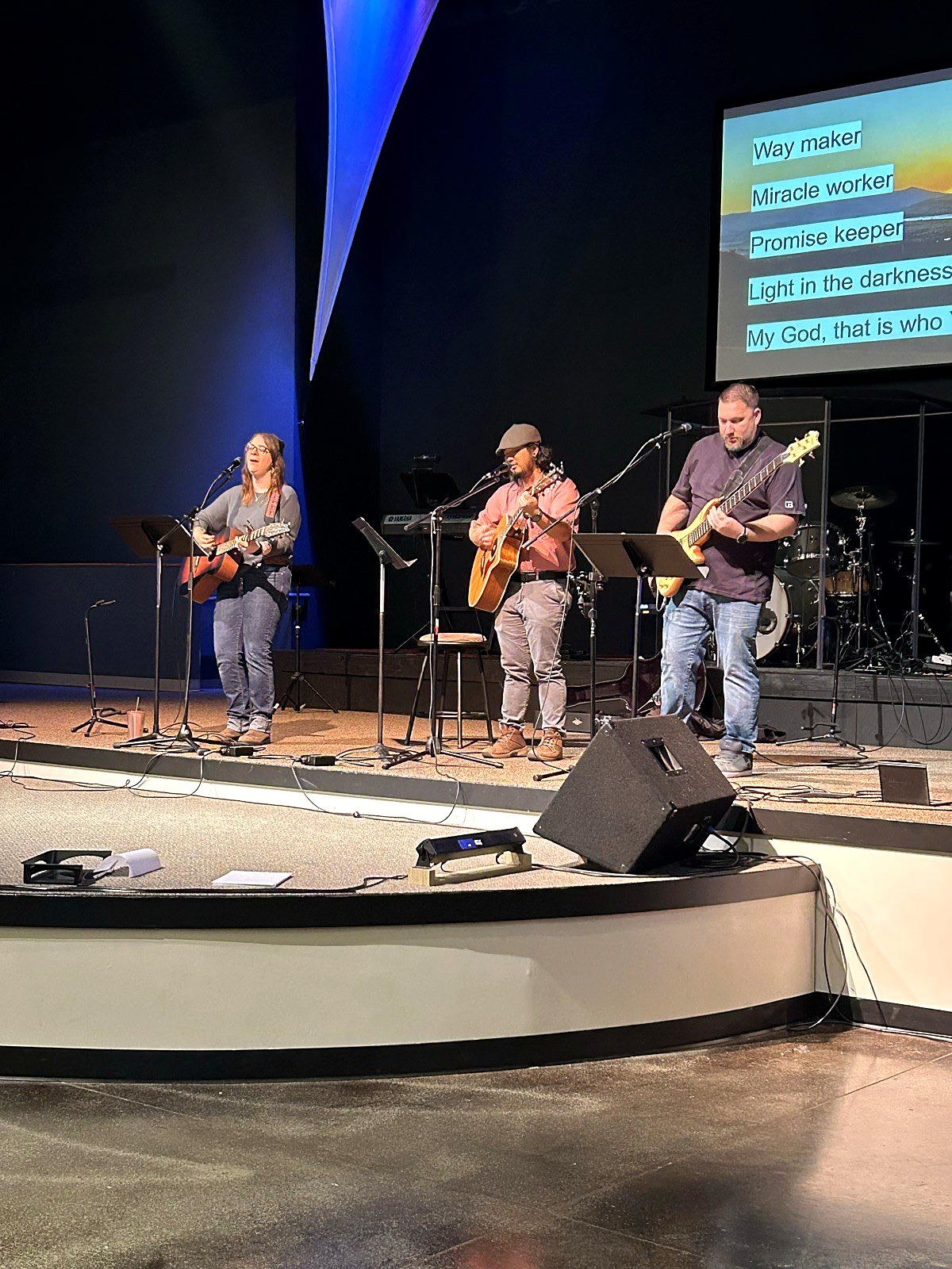 Students leading worship on stage with guitars