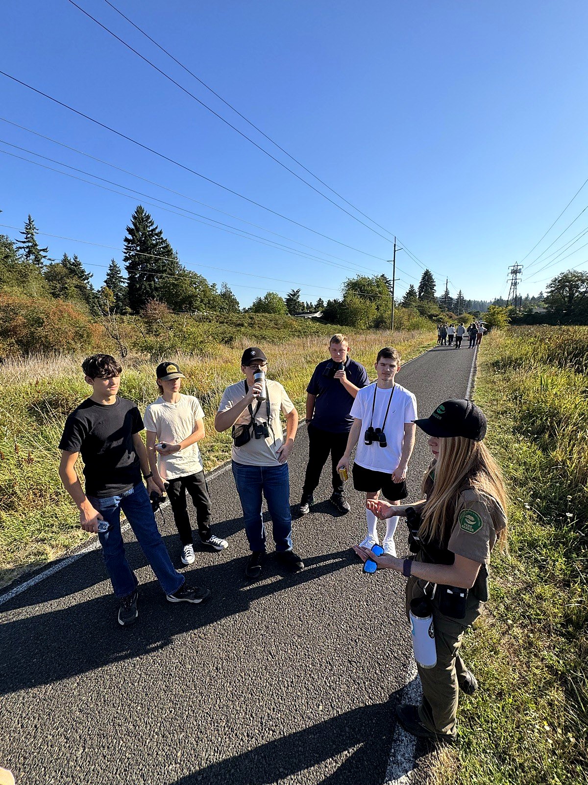 High school students on an outdoor science field study with a guide