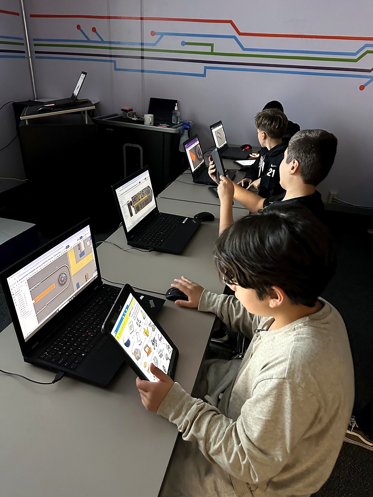 Students working on laptops and tablets in the computer lab